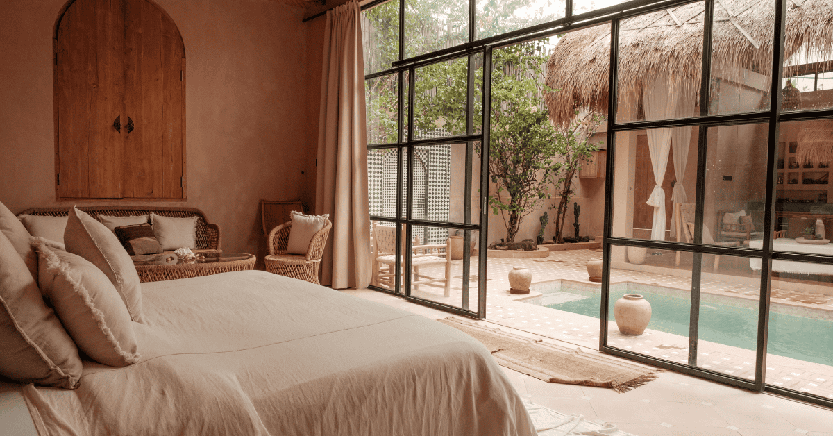 Hotel room with double bed facing glass door with outdoor pool